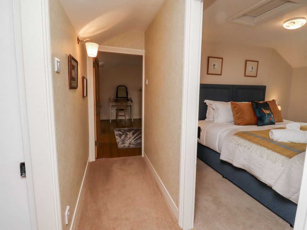 A hallway leading to a bedroom with a bed and decor at Peary House in Alnwick