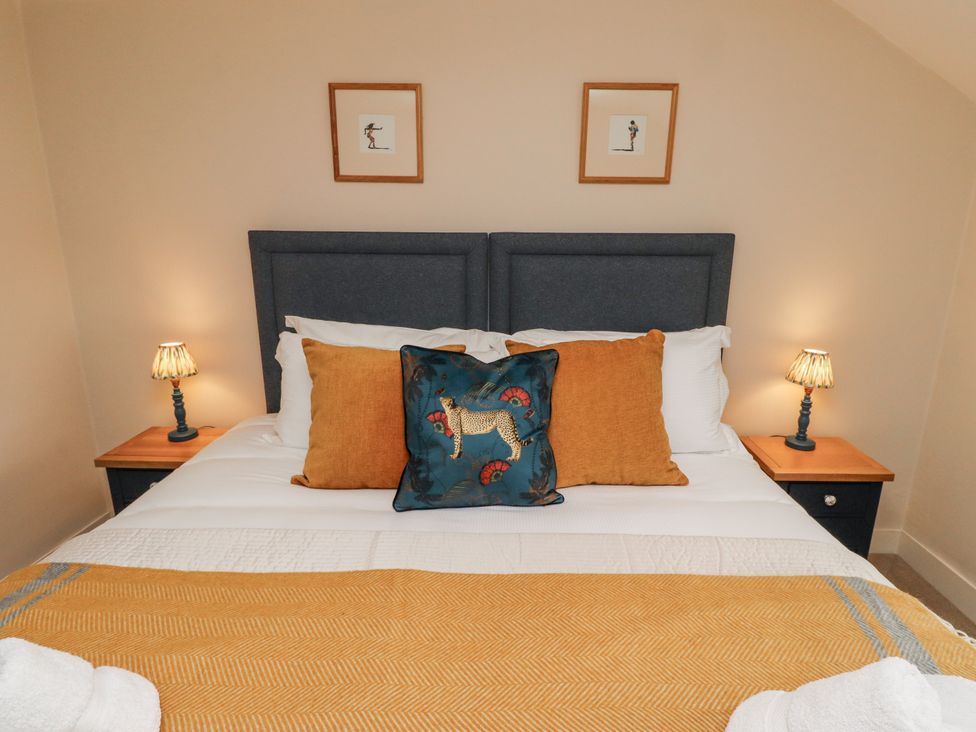 A bedroom with a bed and bedside tables at Peary House in Alnwick