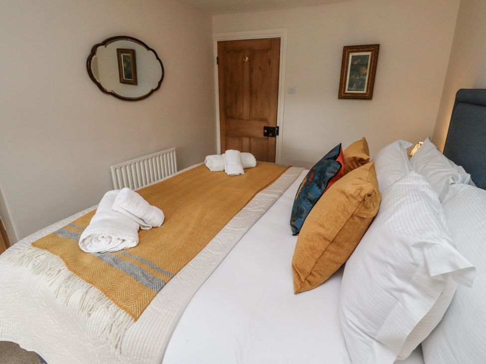 A bedroom with a bed and decorative pillows at Peary House in Alnwick