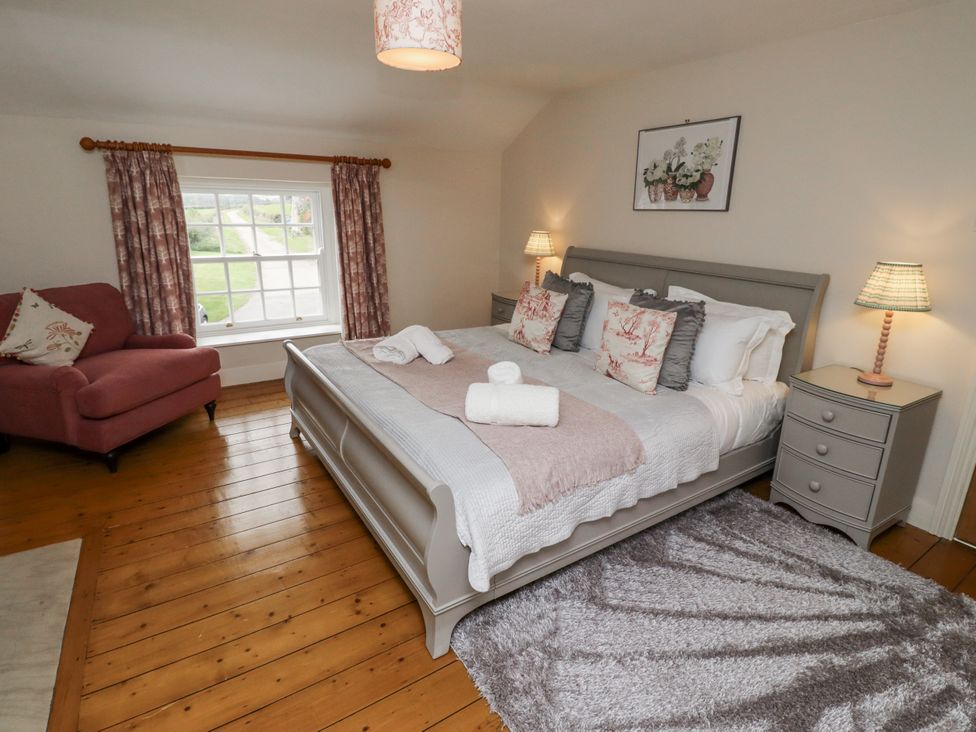 A bedroom with a bed and a chair at Peary House in Alnwick