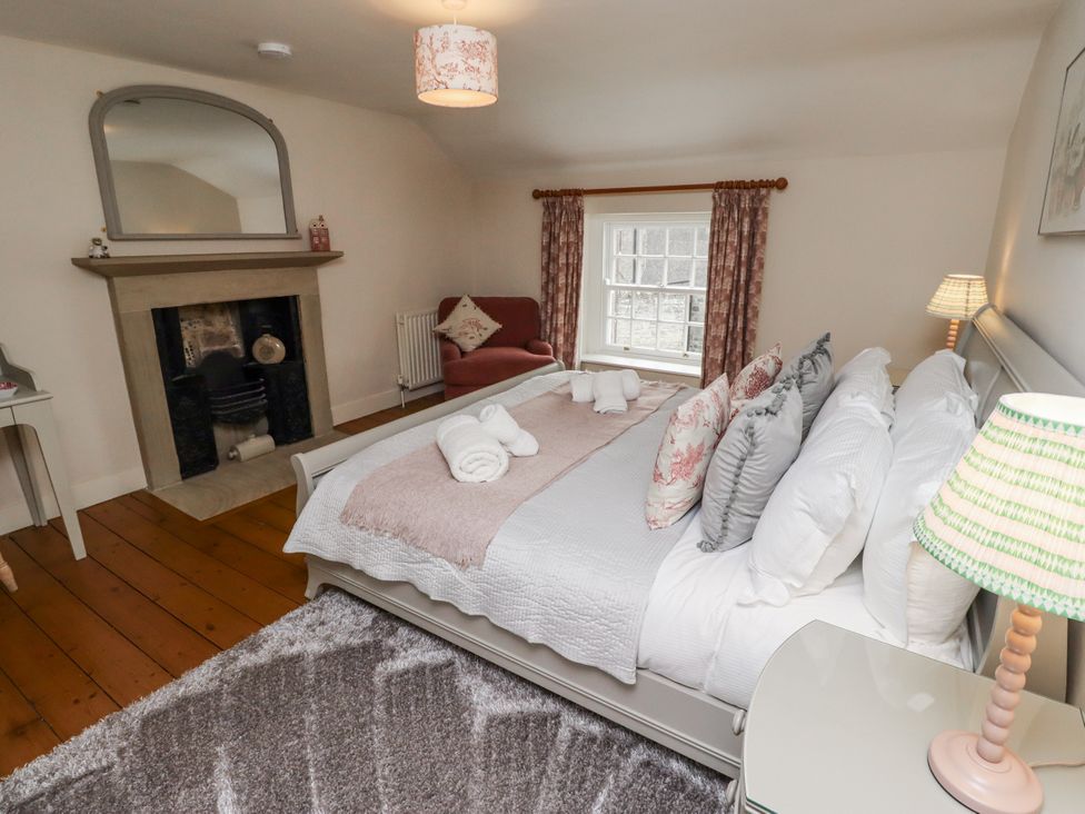 A bedroom with a bed and sofa at Peary House in Alnwick