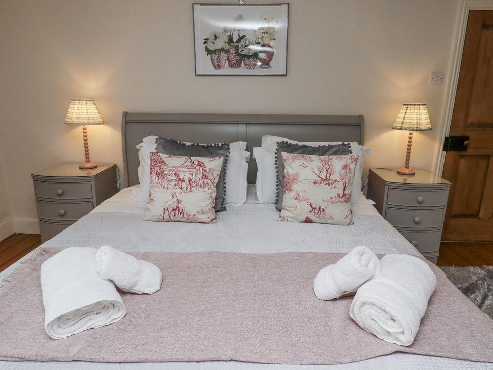 A bedroom with a bed and bedside tables at Peary House in Alnwick