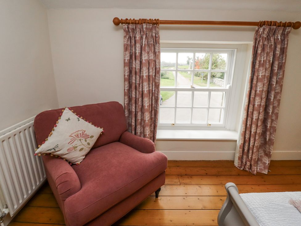 A chair near a window with curtains at Peary House in Alnwick