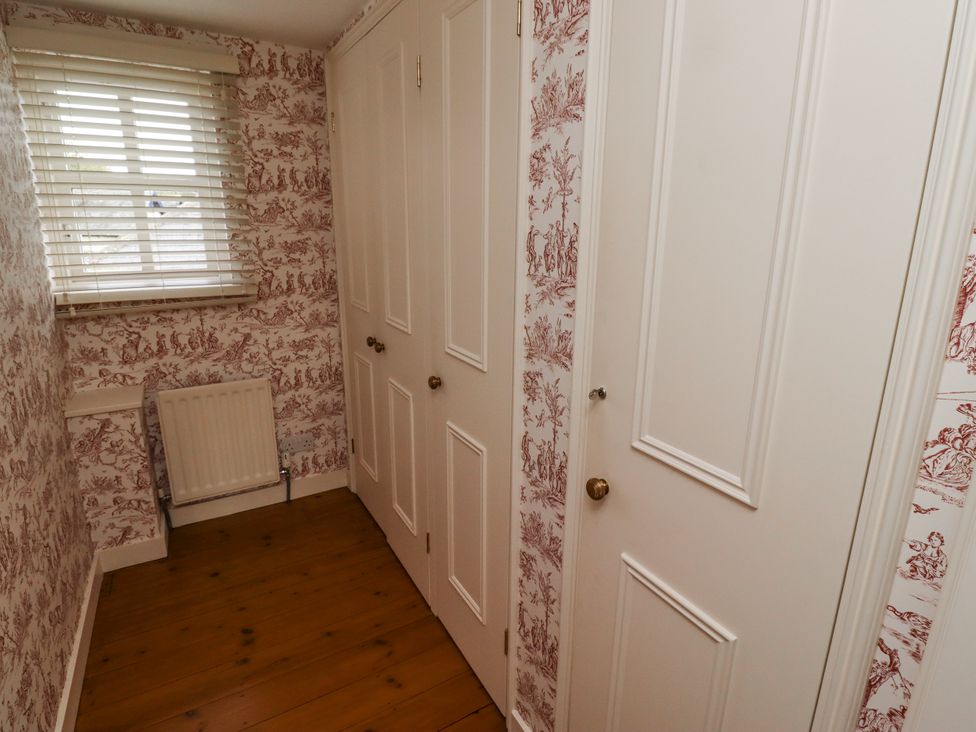 A hallway with closet doors and a window at Peary House in Alnwick