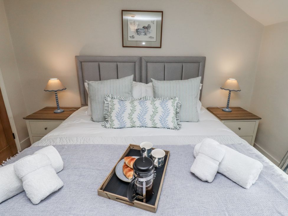 A bedroom with a bed and tray on the bedside table at Peary House in Alnwick