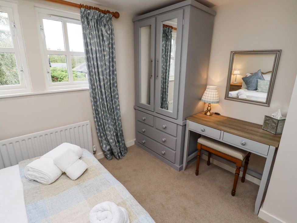 A bedroom with a bed, wardrobe, and dresser at Peary House in Alnwick
