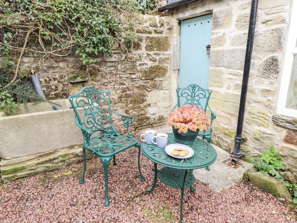 A garden with chairs and a table containing a flower pot at Peary House in Alnwick