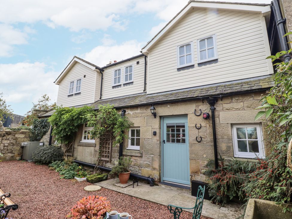 An outdoor view of a house with gravel and plants at Peary House in Alnwick