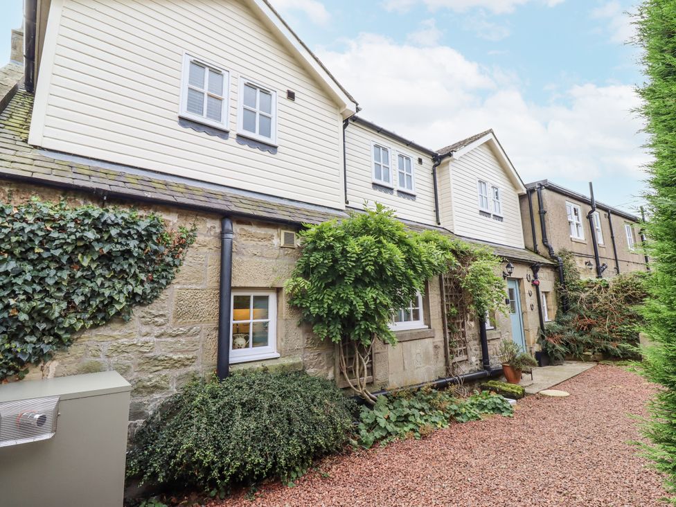 An outdoor view of a house with plants and gravel path at Peary House in Alnwick