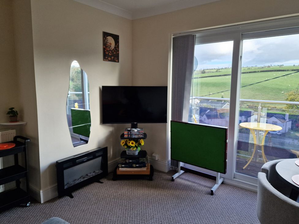 A living room with a TV and a fireplace at Golygfa in Abergele