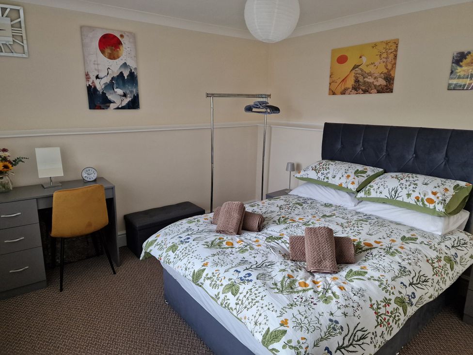 A bedroom with a bed and desk at Golygfa in Abergele