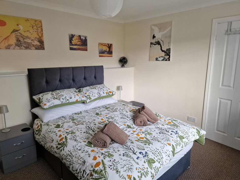 A bedroom with a bed and wall art at Golygfa in Abergele