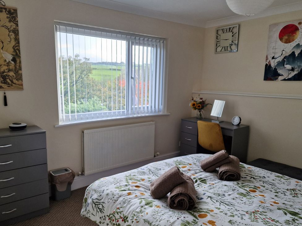 A bedroom with a bed and desk at Golygfa Abergele