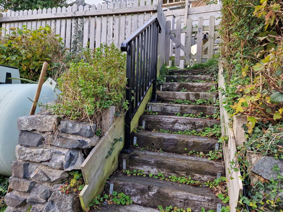A garden with wooden stairs and railing at Golygfa Abergele