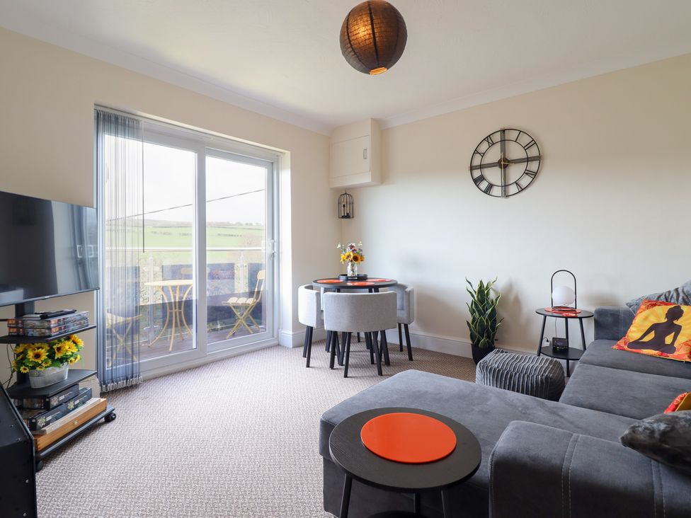 A living room with a sofa and dining table at Golygfa in Pandy Tudur near Llanrwst