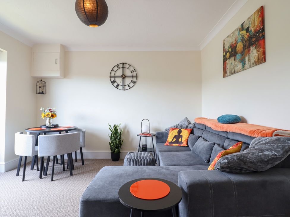 A living room with a sofa and dining area at Golygfa near Pandy Tudur