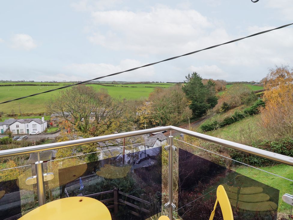 A balcony view overlooking fields and trees at Golygfa Pandy Tudur near Llanrwst