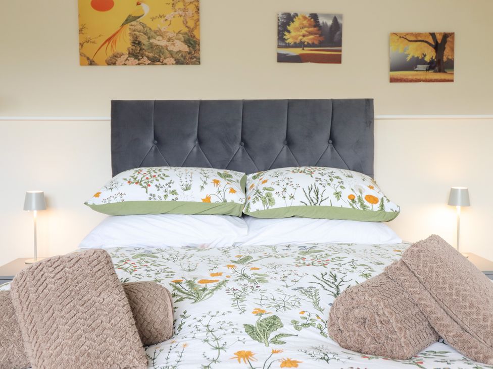 A bedroom with a bed and decorative pillows at Golygfa, Pandy Tudur near Llanrwst
