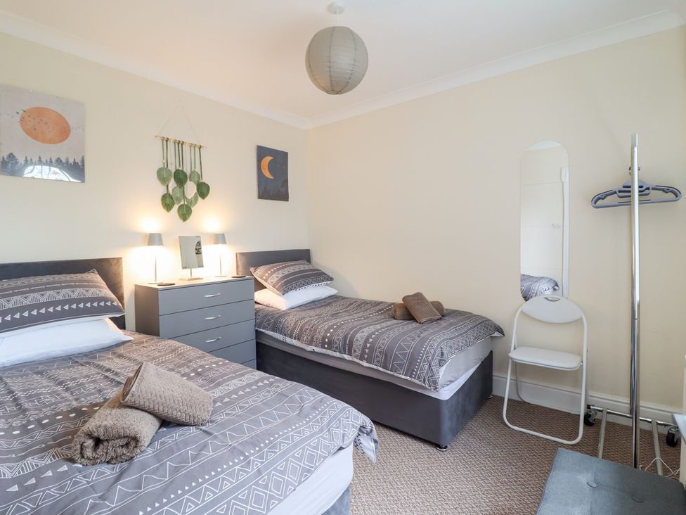 A bedroom with twin beds and a dresser at Golygfa in Pandy Tudur near Llanrwst