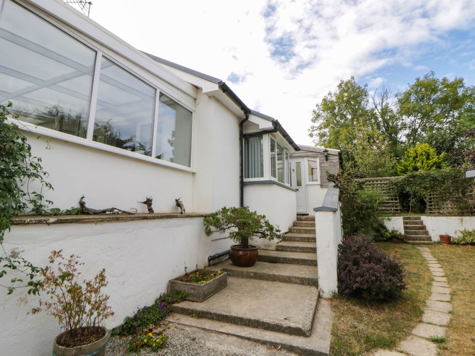 A house exterior with steps leading to the entrance and a garden at Llain in Cardigan