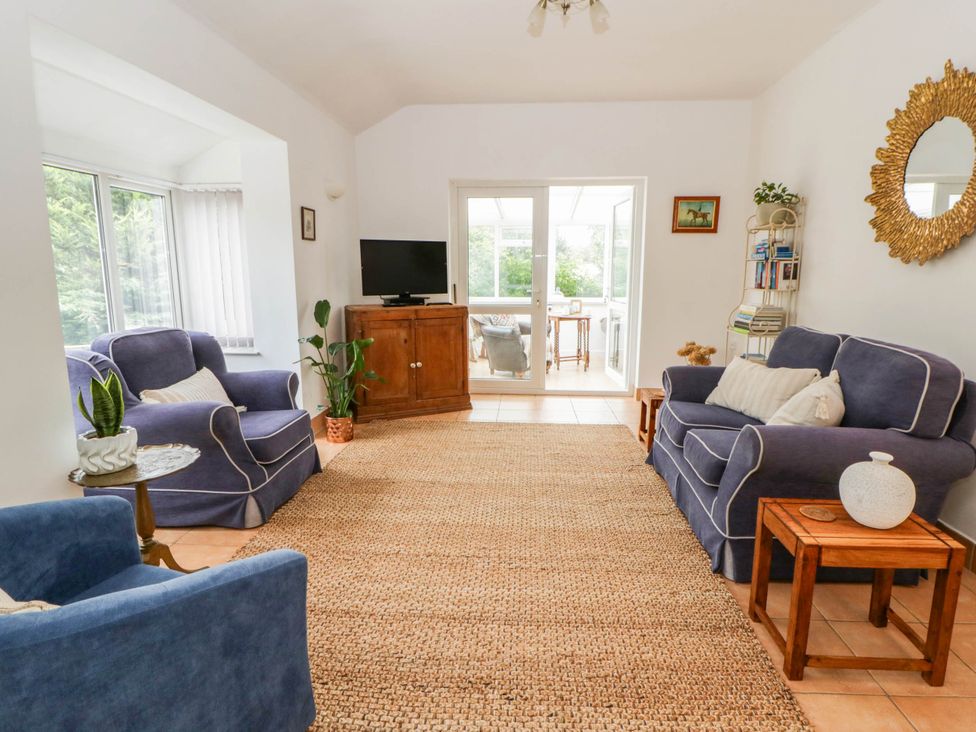A living room with sofas and a television at Llain in Cardigan