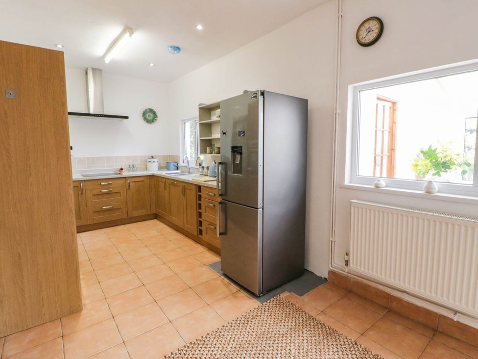 A kitchen with cabinets and a refrigerator at Llain in Cardigan