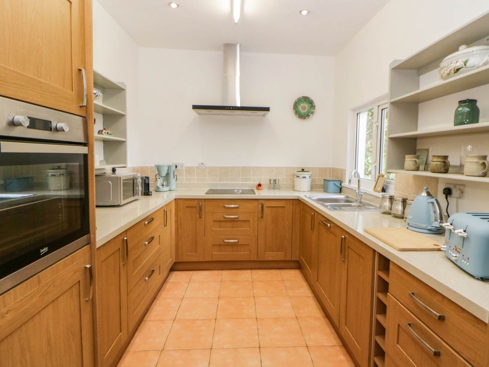 A kitchen with cabinets and appliances at Llain in Cardigan