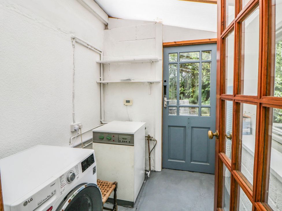 A laundry room with a washing machine and dryer at Llain in Cardigan