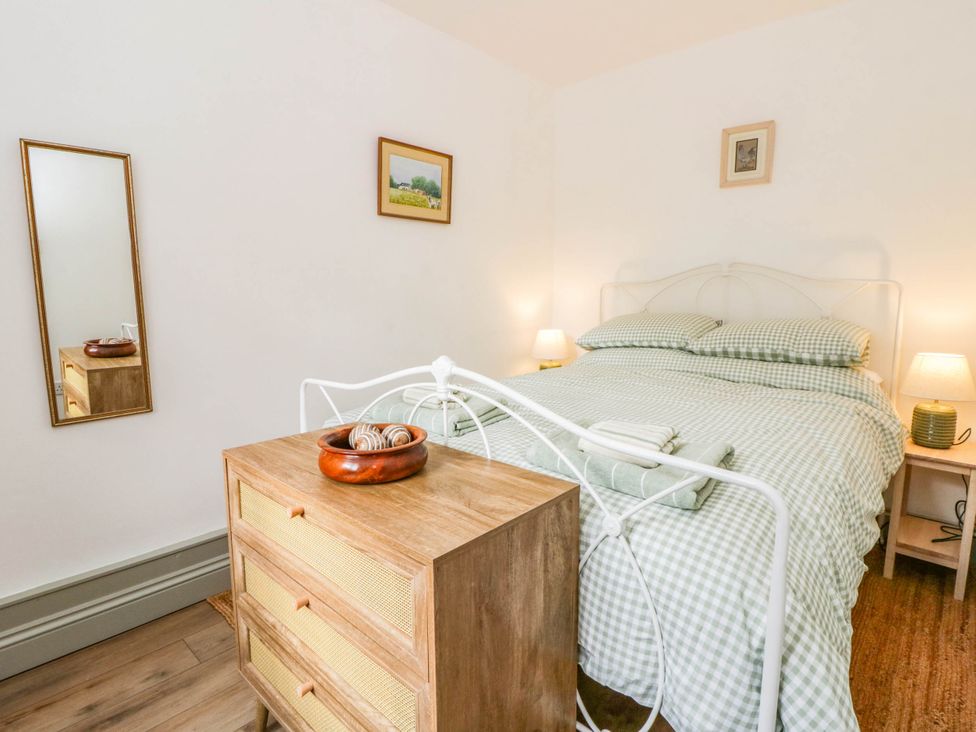A bedroom with a bed and nightstand at Llain in Cardigan