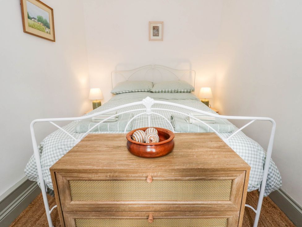 A bedroom with a bed and dresser at Llain in Cardigan