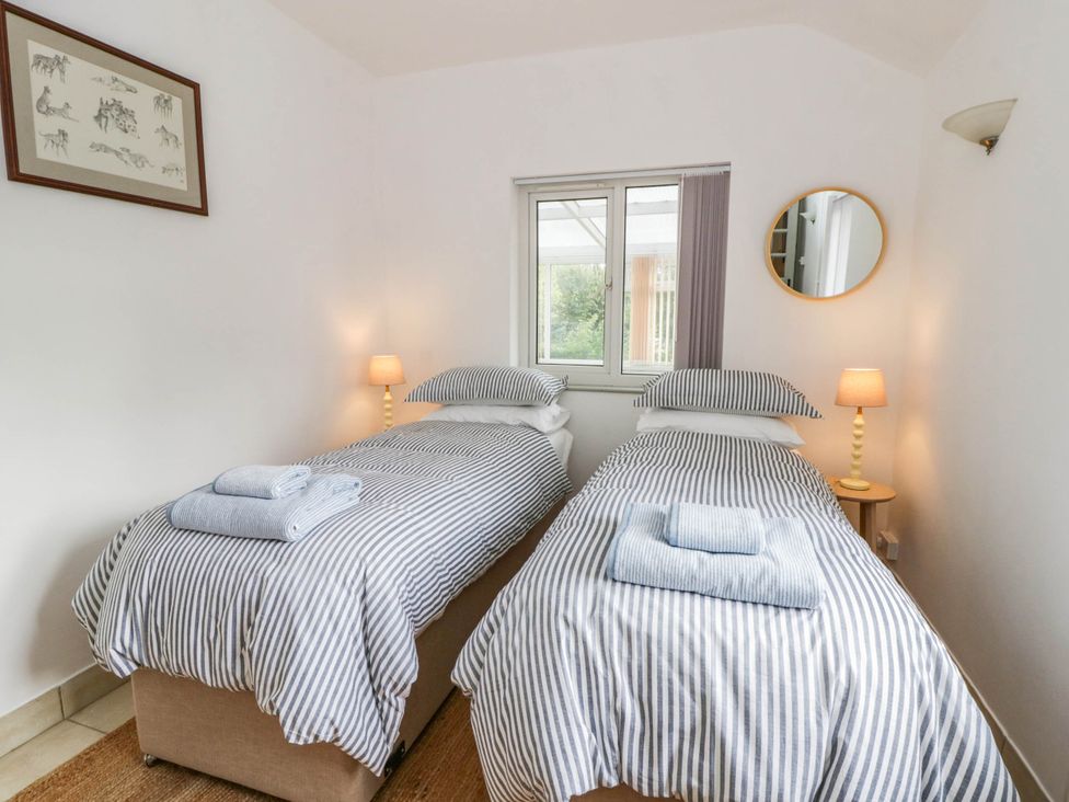 A bedroom with two beds and a window at Llain in Cardigan
