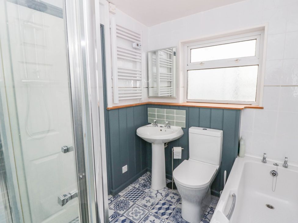 A bathroom with shower, sink, toilet, and bathtub at Llain in Cardigan