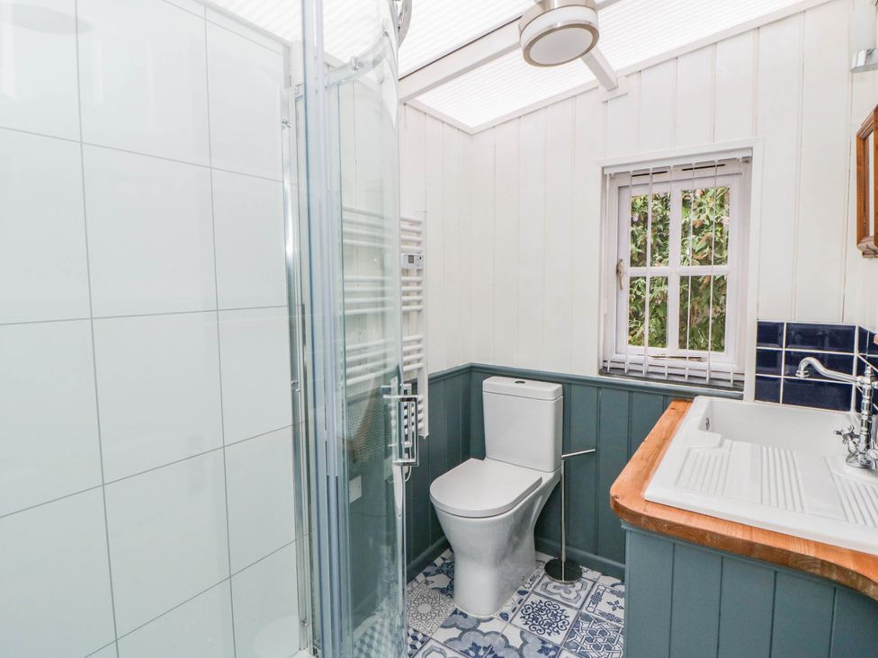 A bathroom with a shower, toilet, and sink at Llain in Cardigan