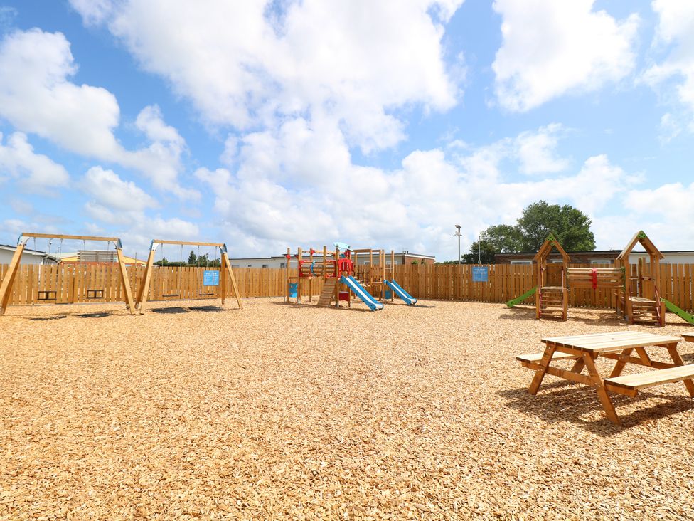 An outdoor play area with swings and slides at 440 California Sands