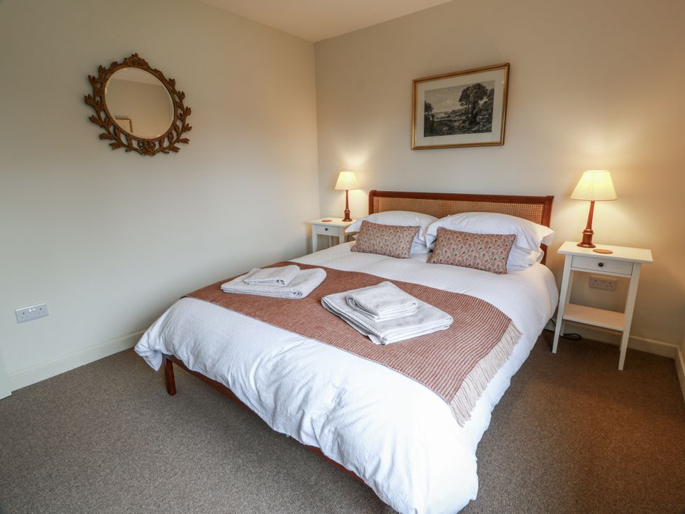 A bedroom with a bed and nightstands at The Dairy in Newton Stewart