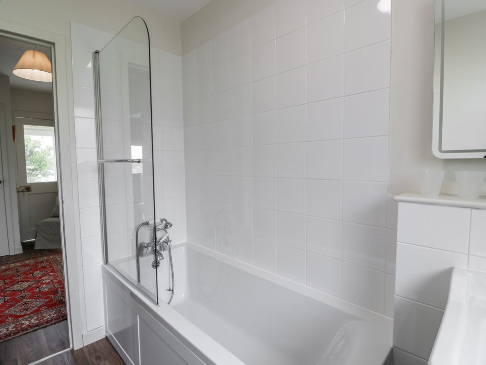 A bathroom with a bathtub and shower screen at The Dairy in Newton Stewart