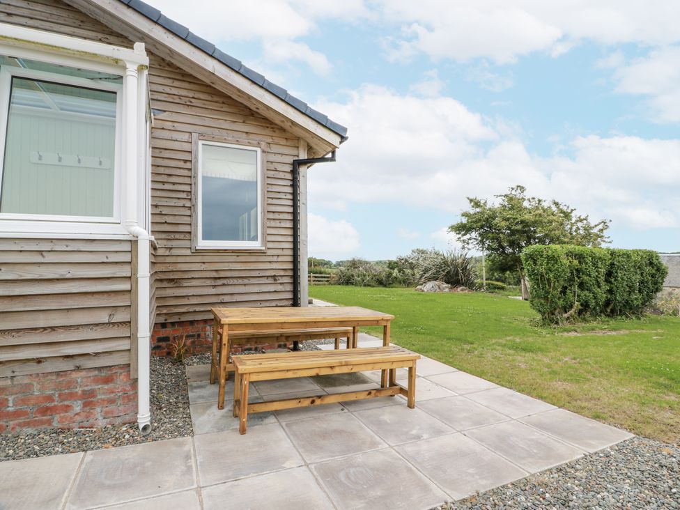 An outdoor seating area with a wooden table and benches at The Dairy in Newton Stewart