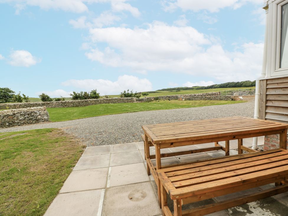 An outdoor seating area with a table and bench at The Dairy in Newton Stewart