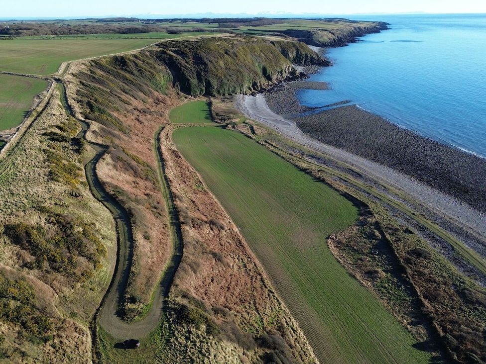 A coastal view of a cliff with fields and a road at The Dairy in Newton Stewart