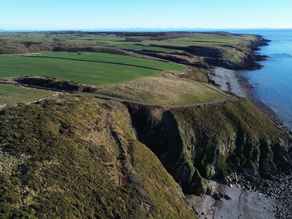 Aerial view of coastline and fields near the ocean at The Dairy in Newton Stewart