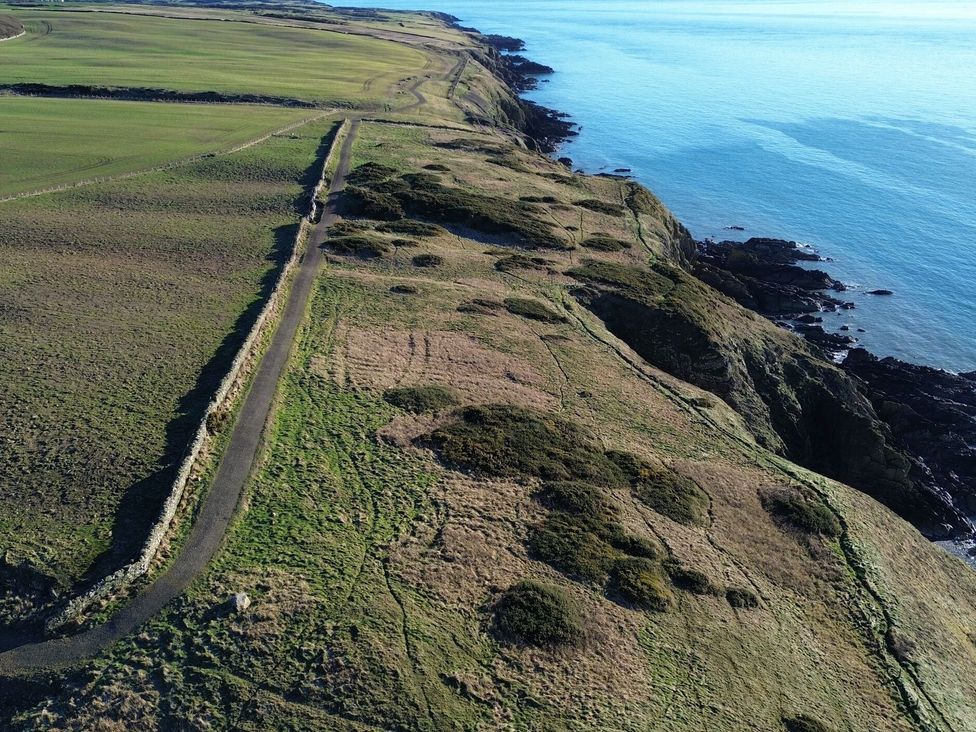A coastline with a path and fields at The Dairy in Newton Stewart
