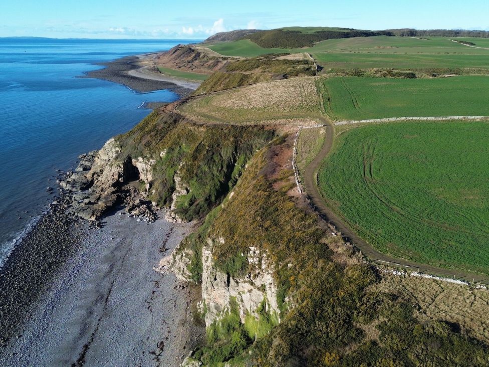A coastal view with cliffs and beach at The Dairy in Newton Stewart