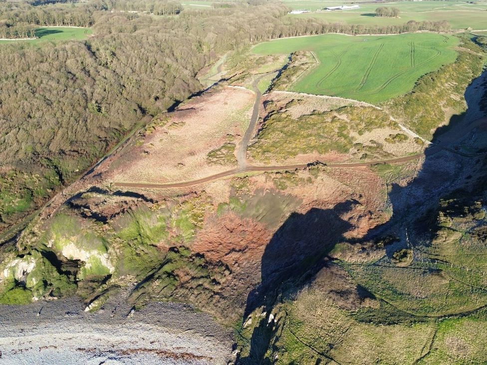 An aerial view of a landscape with cliffs and fields at The Dairy in Newton Stewart