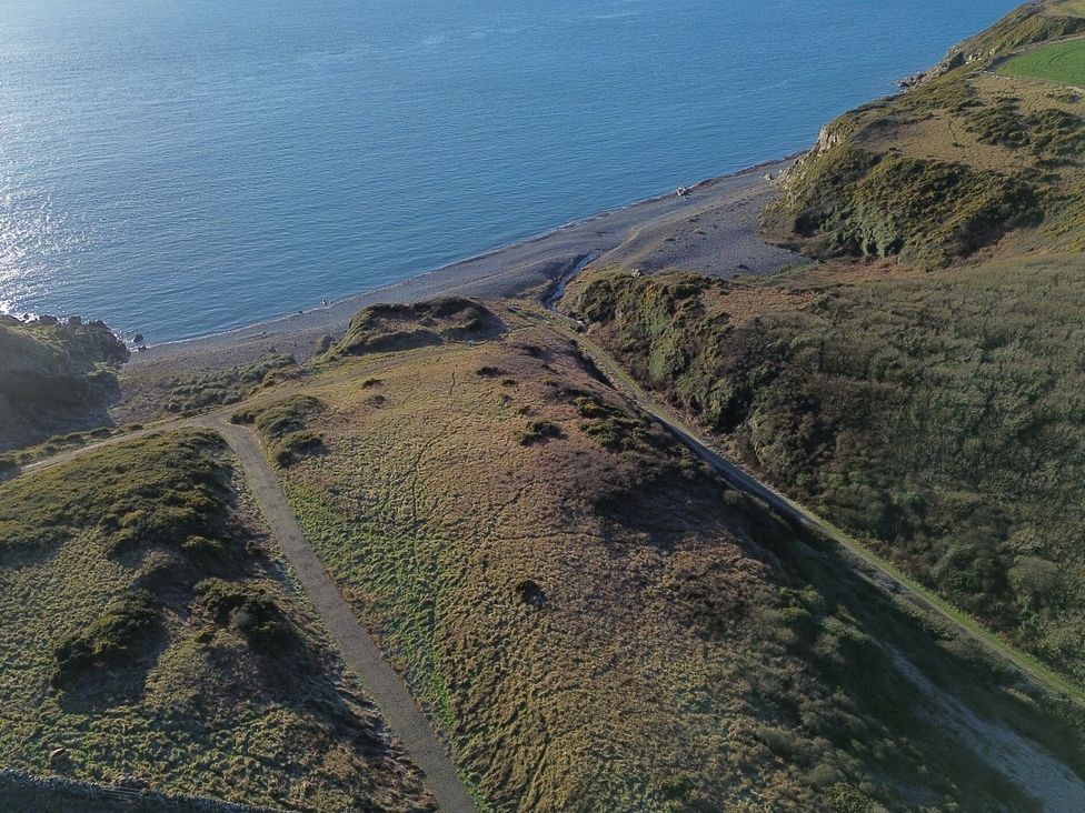 An aerial view of a coastline with beach and grass near the sea at The Dairy in Newton Stewart