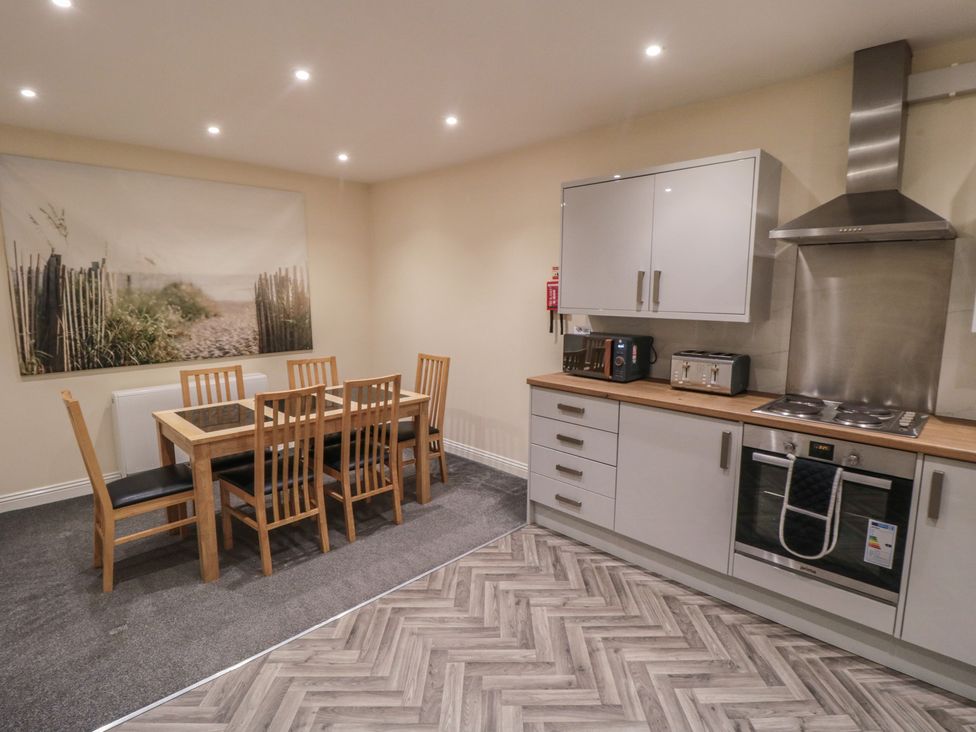 A kitchen with a dining table and chairs at The Newborough Apartment 3 Scarborough