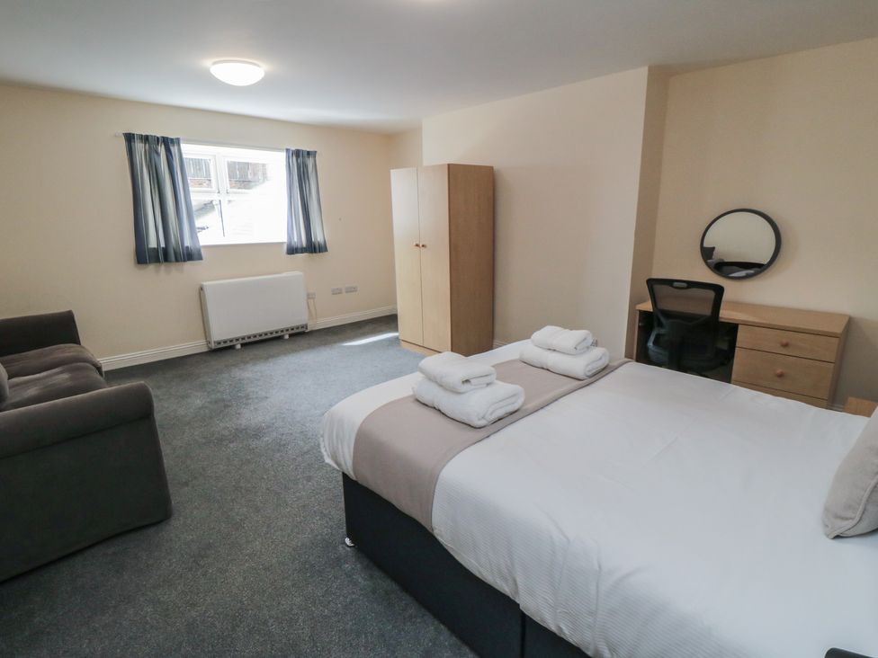 A bedroom with a bed and a desk at The Newborough Apartment 3 Scarborough