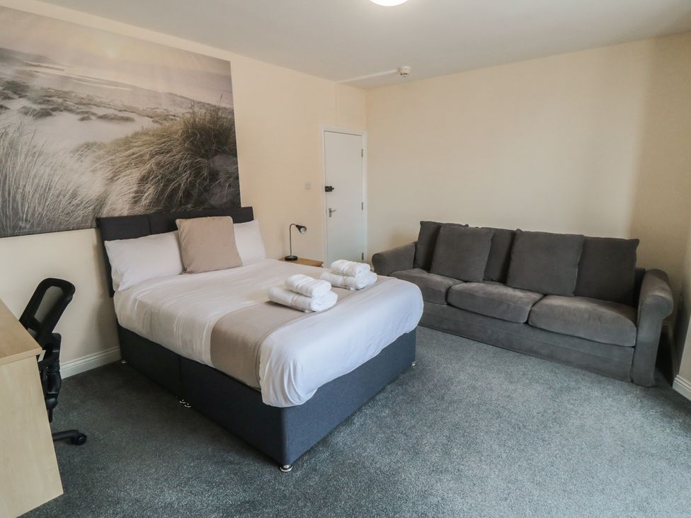 A bedroom with a bed and sofa at The Newborough Apartment 3 in Scarborough