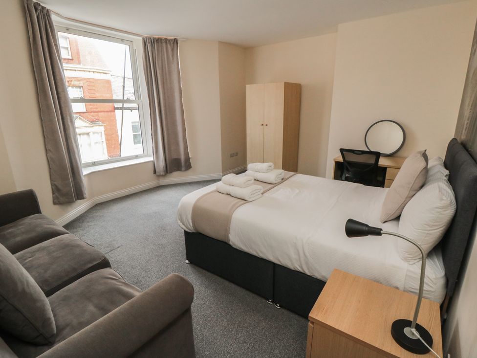 A bedroom with a bed and a sofa at The Newborough Apartment 3 in Scarborough