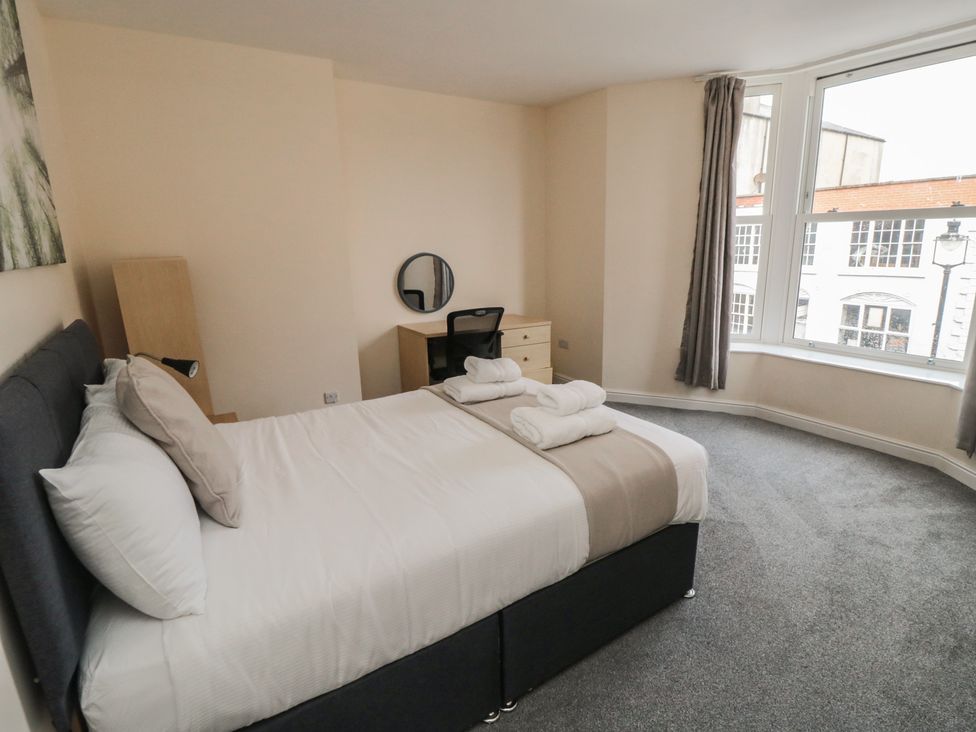 A bedroom with a bed, desk, and window at The Newborough Apartment 3 Scarborough