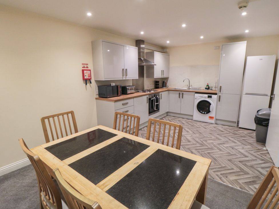 A kitchen with a table and chairs at The Newborough Apartment 4 in Scarborough